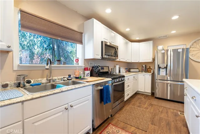 a kitchen with a sink cabinets stainless steel appliances and window