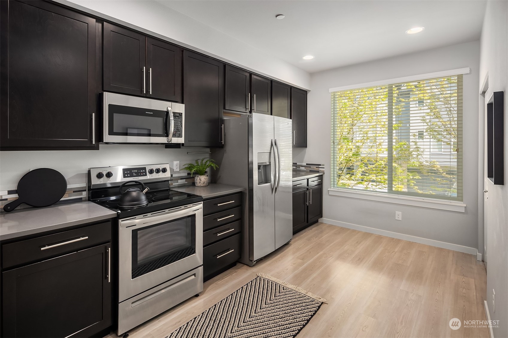 15720 Meadow Road, Unit C2 Lynnwood, WA 98087 - Photo 11 of 23 a kitchen with a stove a sink and a microwave