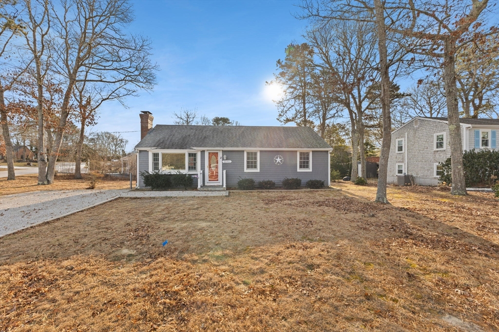 a view of a house with a yard and large tree