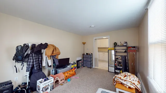 a bedroom with a bed and a lamp on the dresser