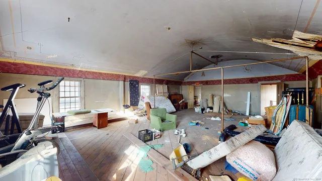 a view of a room with gym equipment and wooden floor