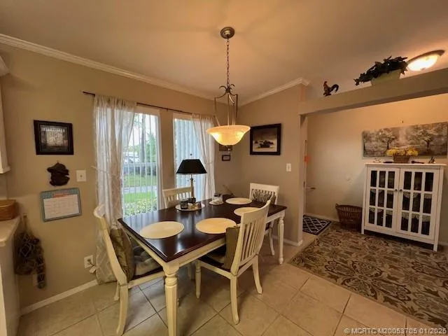 a dining area with a table chairs and a kitchen view