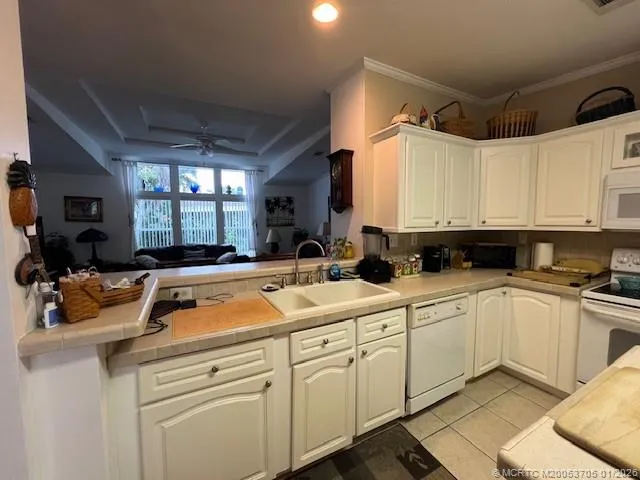 a kitchen with white cabinets and sink