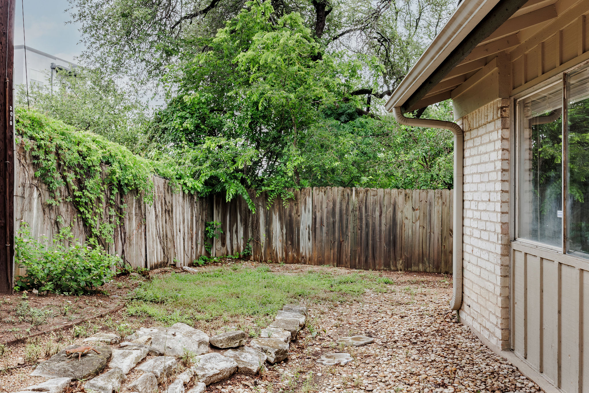 2012 Cody Court Austin, TX 78704 - Photo 39 of 40 A private backyard oasis awaits, featuring a sturdy wooden fence and ample green space for leisure.