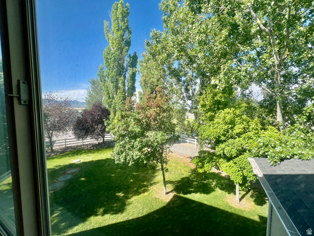 812 East Bates Cyn Road Tooele, UT 84074 - Photo 66 of 144 Lush green lawn with stepping stones, bordered by a white fence