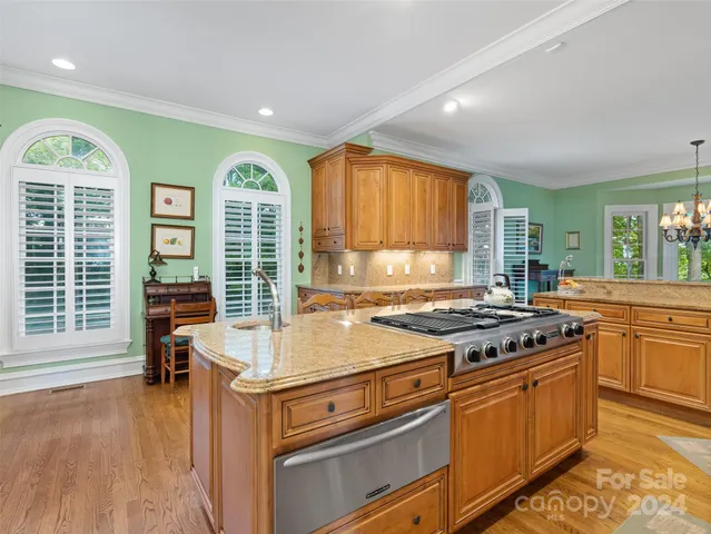a kitchen with a stove a sink and a wooden cabinets