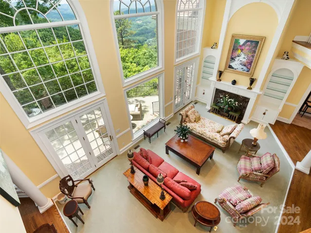 a living room with furniture and floor to ceiling windows