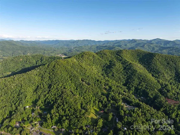 a view of a mountain range with lush green forest