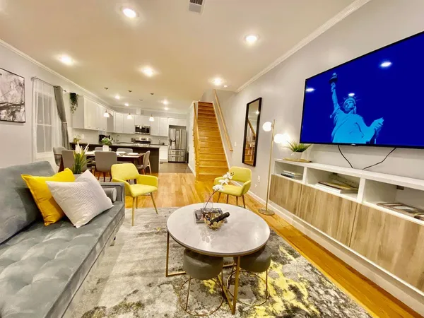 a living room with furniture a flat screen tv and a table