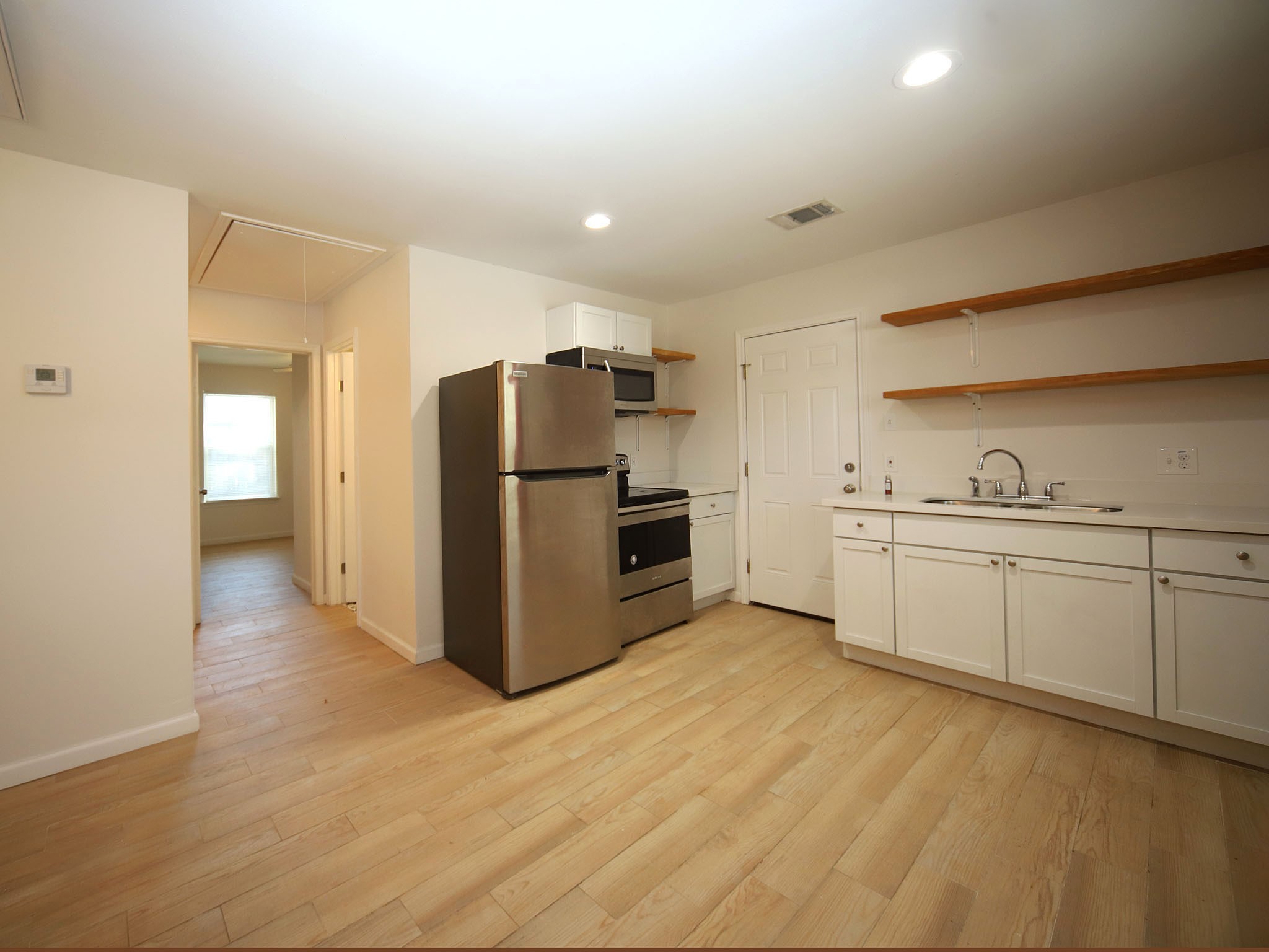 6709 Greenhurst Street, Unit A Houston, TX 77091 - Photo 3 of 8 a kitchen with a refrigerator a sink and cabinets