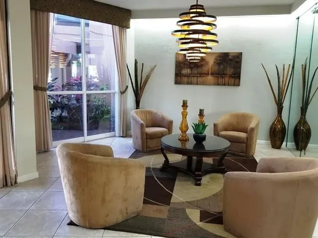 a living room with furniture potted plant and a large window