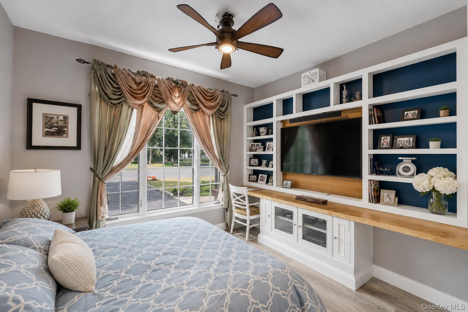 19 Joan Road Bay Shore, NY 11706 - Photo 21 of 50 Room featuring a large window with draped valances, a ceiling fan with integrated lighting, and wood-finish flooring