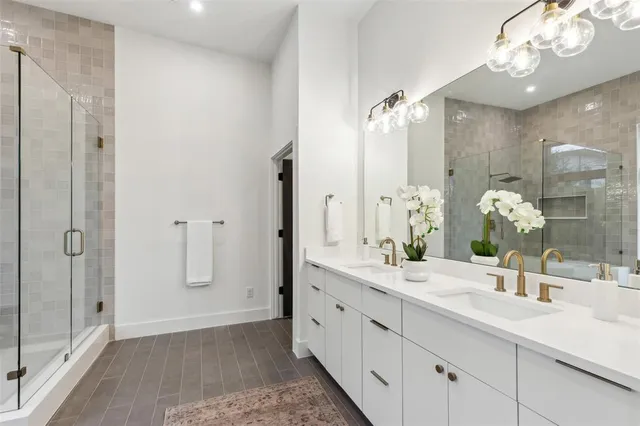 a bathroom with a double vanity sink mirror and shower