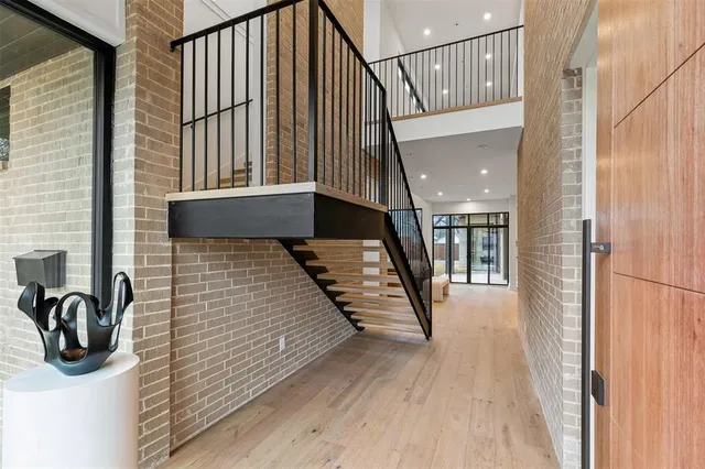 a view of a hallway with wooden floor and staircase