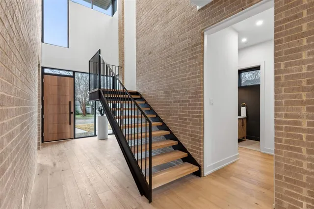 a view of a hallway with wooden floor and staircase
