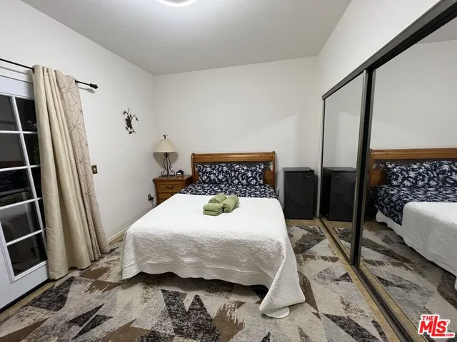 a spacious bathroom with a granite countertop sink a toilet a mirror and shower