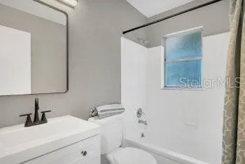 a bathroom with a sink mirror vanity and toilet