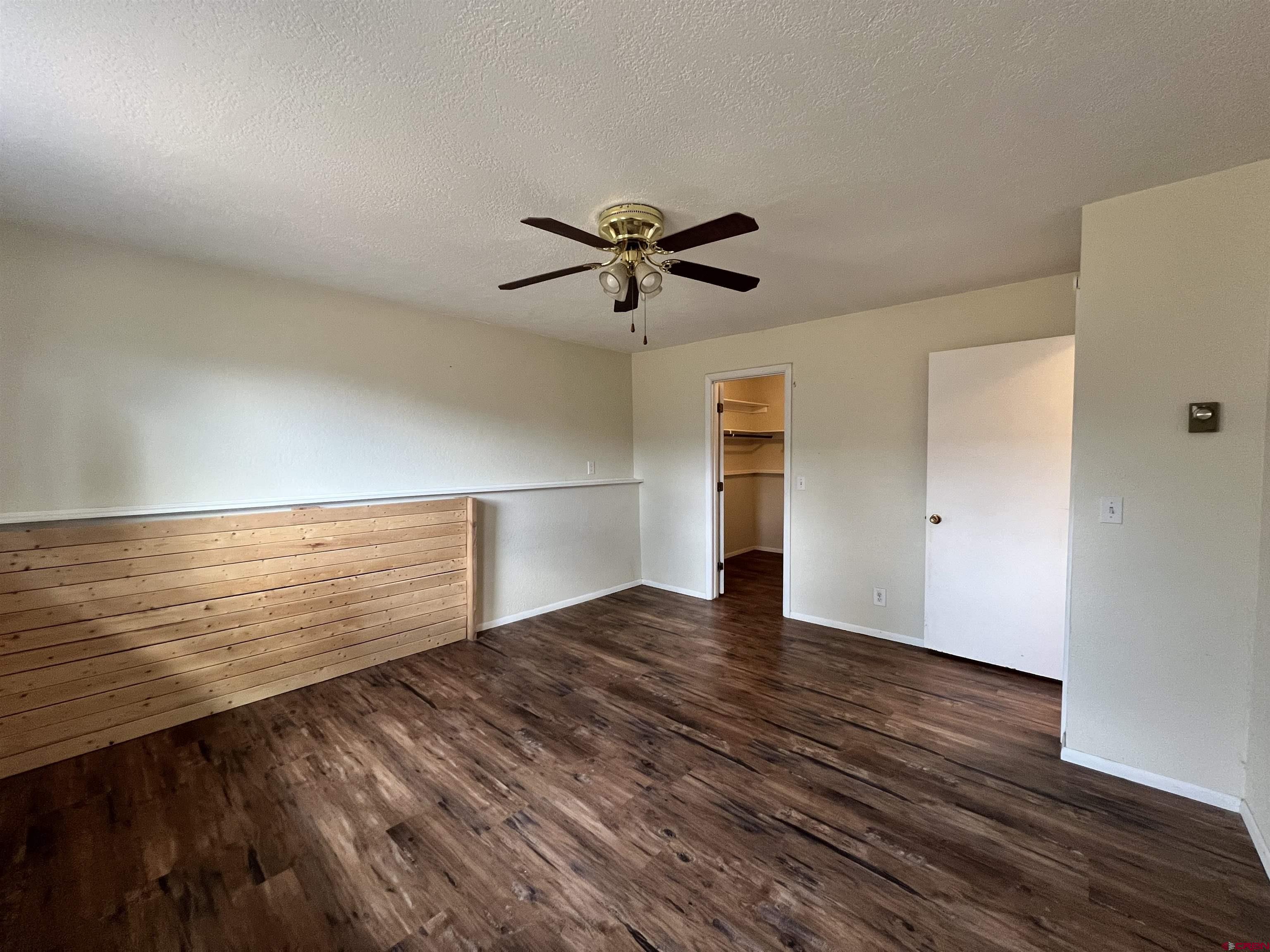 1328 Jackson Street Cortez, CO 81321 - Photo 20 of 37 a view of a room with wooden floor and a ceiling fan