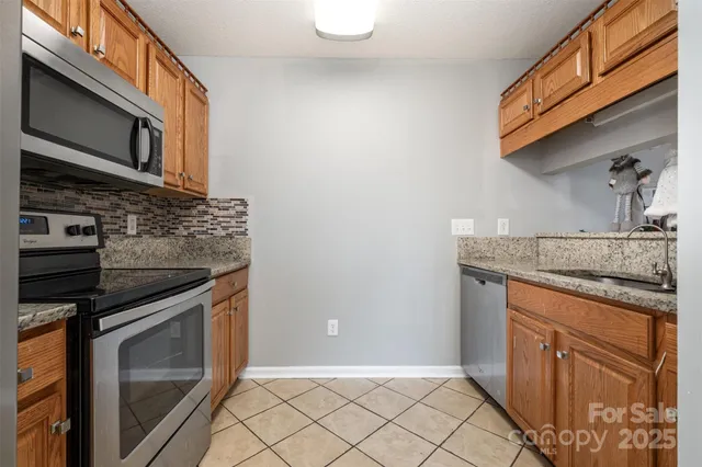 a kitchen with granite countertop cabinets stainless steel appliances and a counter space