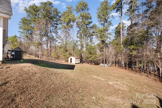 a view of large tree with wooden fence