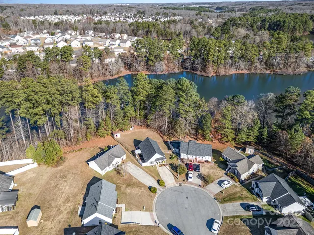 an aerial view of lake and residential houses with outdoor space