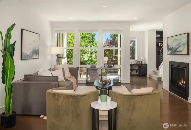 a living room with fireplace furniture and a large window