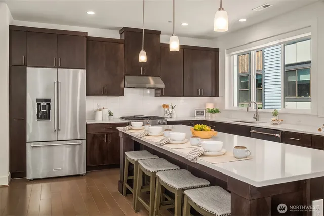 a kitchen with a refrigerator a sink and a stove top oven