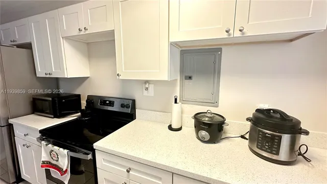a kitchen with a stove and a white cabinets