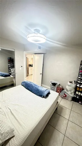 a bedroom with a bed and a large mirror