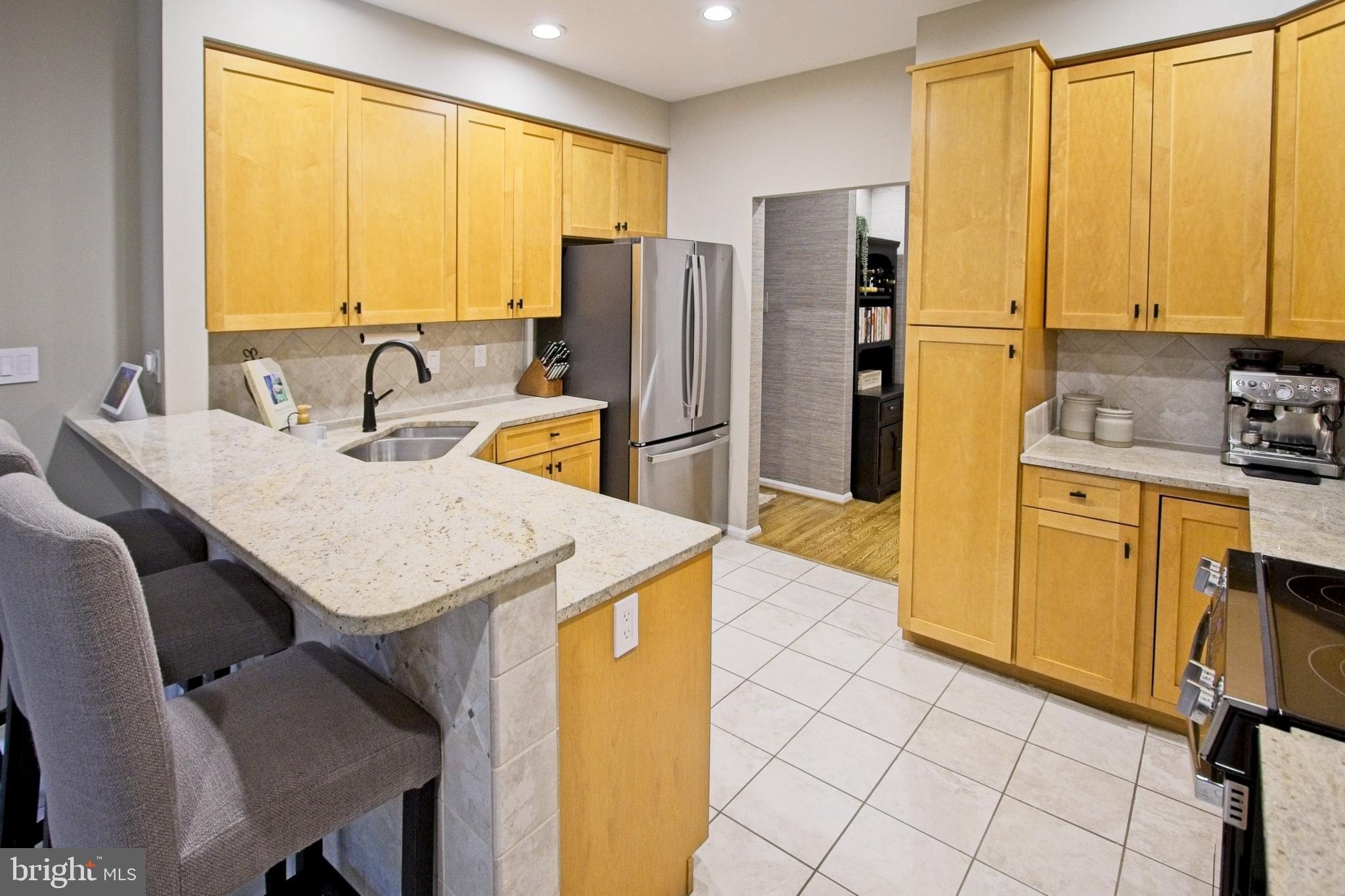 11423 Hollow Timber Way Reston, VA 20194 - Photo 15 of 68 a kitchen with a sink a stove a refrigerator and wooden cabinets