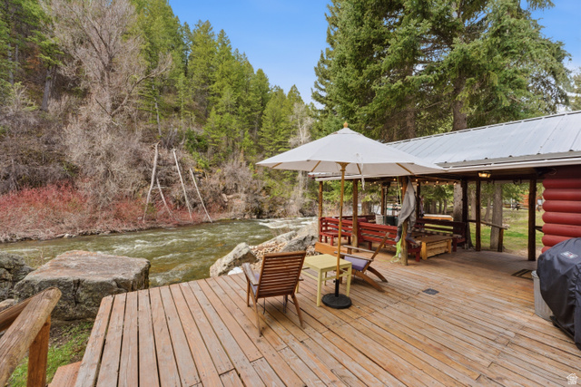6631 Pine Springs Road Kamas, UT 84036 - Photo 8 of 48 Wooden deck with a water view, area for grilling, a lawn, and view of wooded area