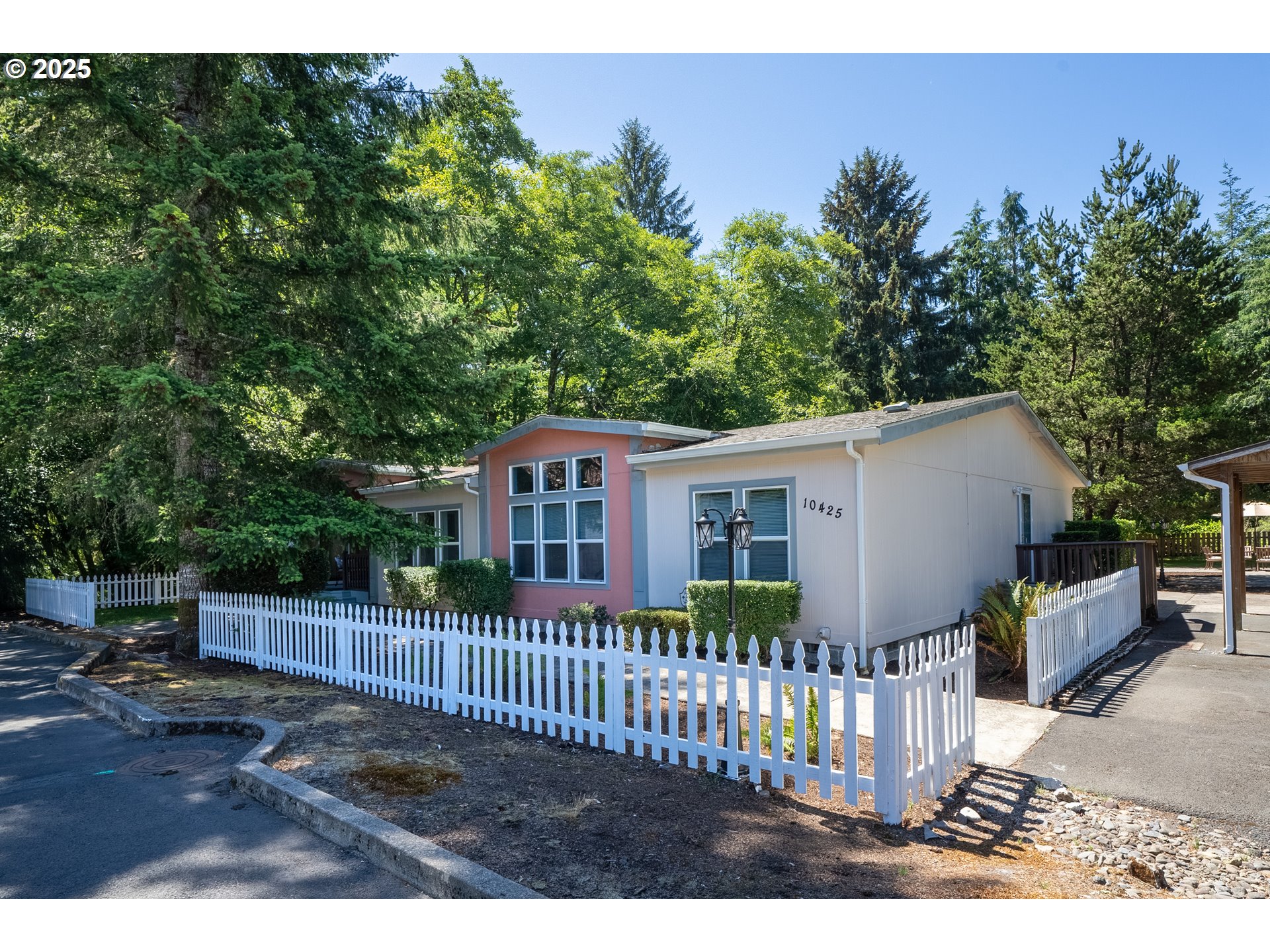 a view of a house with a small yard and wooden fence