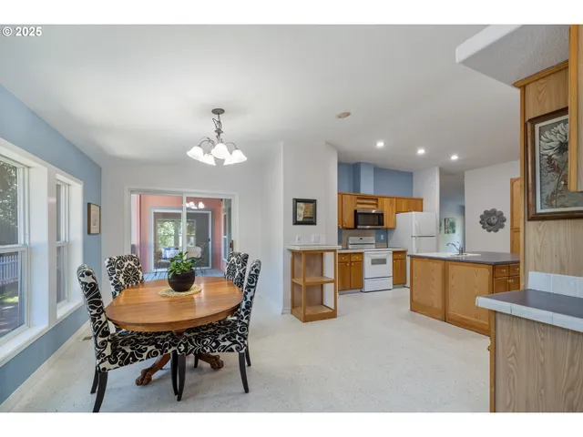 a kitchen with a dining table chairs and microwave