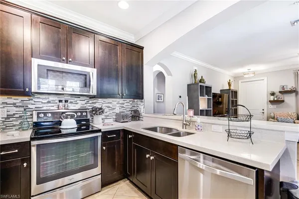 a kitchen with a sink and chairs
