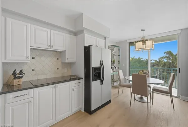a kitchen with a table chairs refrigerator and cabinets