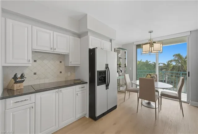 a kitchen with a table chairs refrigerator and cabinets