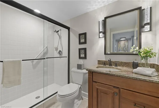 a bathroom with a granite countertop sink toilet and shower