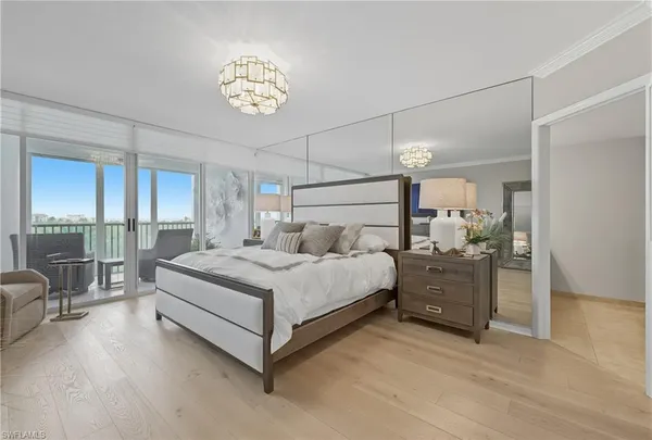a spacious bedroom with a bed and a chandelier
