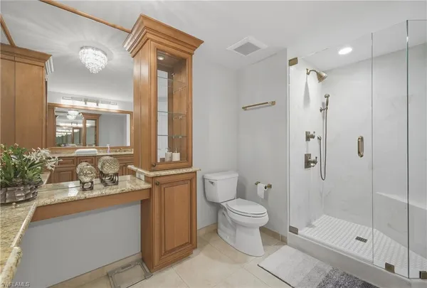 a bathroom with a granite countertop sink toilet and shower