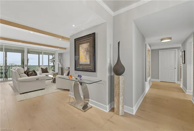 a living room with furniture a large window and a chandelier