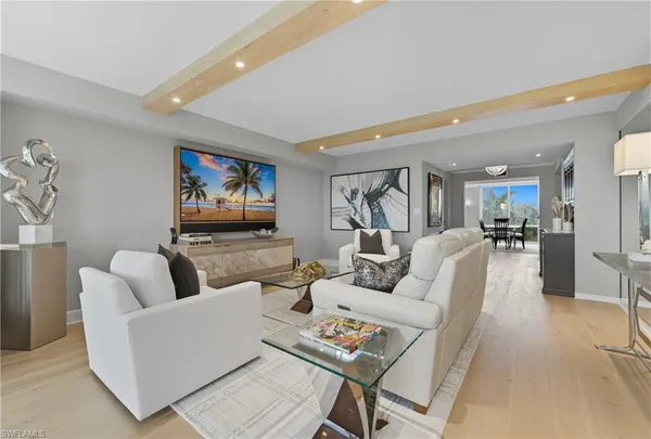 a living room with furniture kitchen view and a potted plant