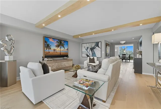 a living room with furniture kitchen view and a potted plant