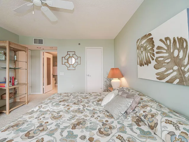 a spacious bedroom with a large bed and a chandelier