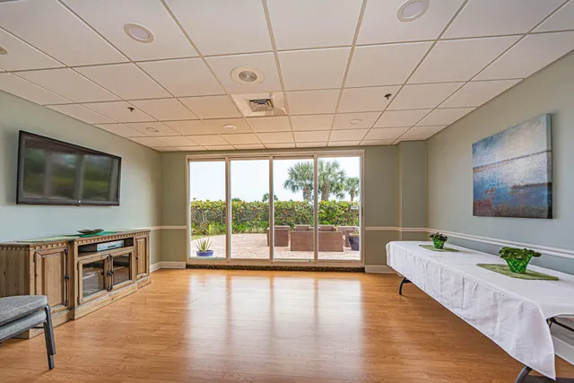 a living room with furniture a flat screen tv and wooden floor