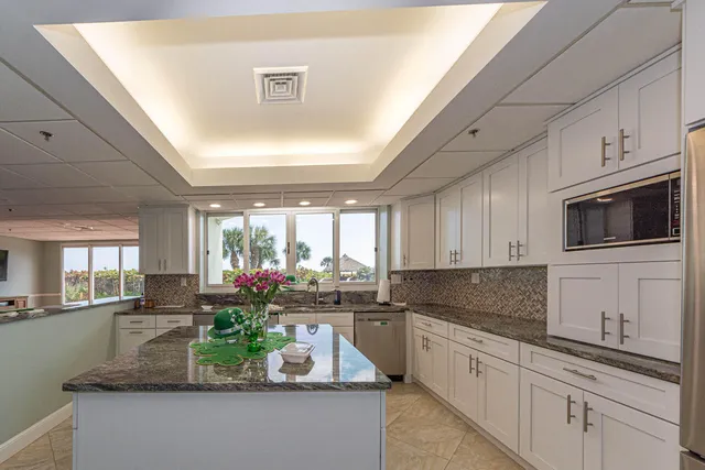 a kitchen with stainless steel appliances granite countertop a sink a stove a microwave a refrigerator and cabinets