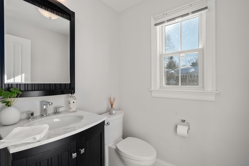 150 Country Club Road Newton, MA 02459 - Photo 11 of 33 a bathroom with a granite countertop sink toilet a mirror and a window