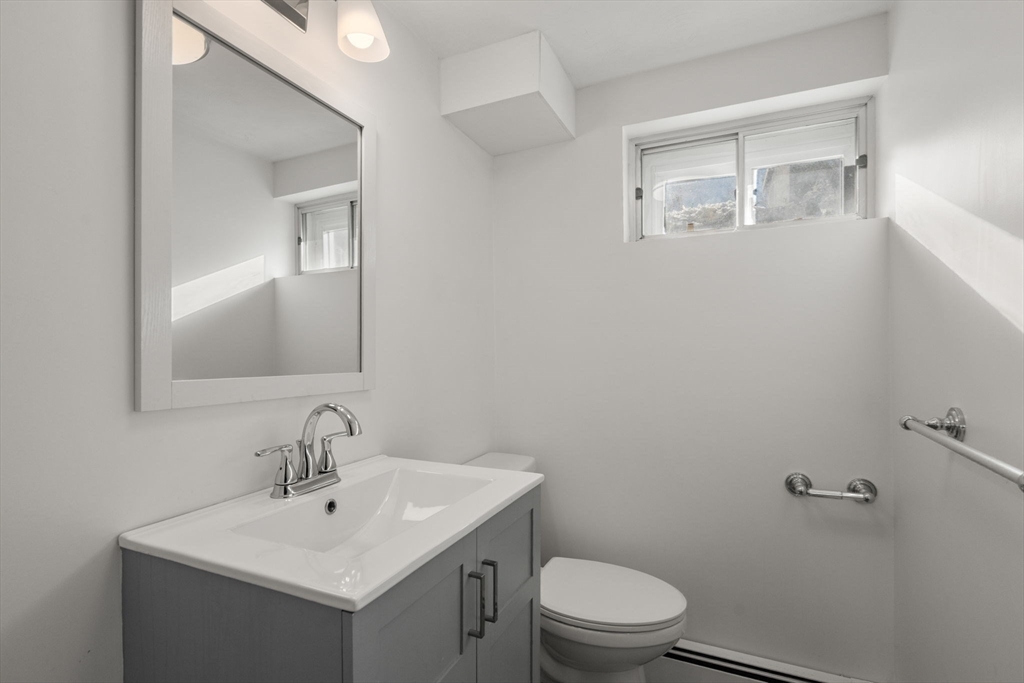 150 Country Club Road Newton, MA 02459 - Photo 24 of 33 a bathroom with a toilet a sink and mirror