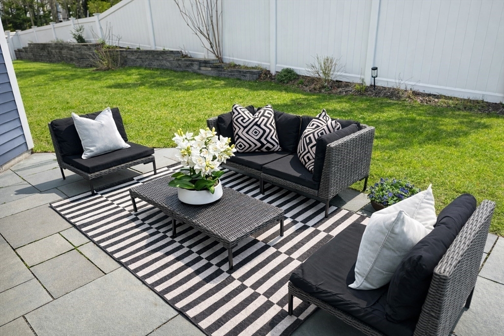 150 Country Club Road Newton, MA 02459 - Photo 28 of 33 a view of a patio with couches table and chairs and garden