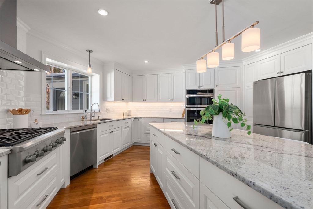 150 Country Club Road Newton, MA 02459 - Photo 7 of 33 a kitchen with kitchen island granite countertop stainless steel appliances and white cabinets