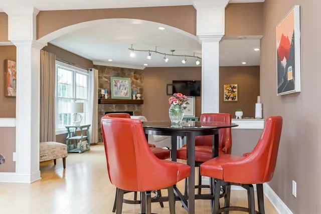 a kitchen with stainless steel appliances granite countertop a stove top oven a sink dishwasher and white cabinets with wooden floor